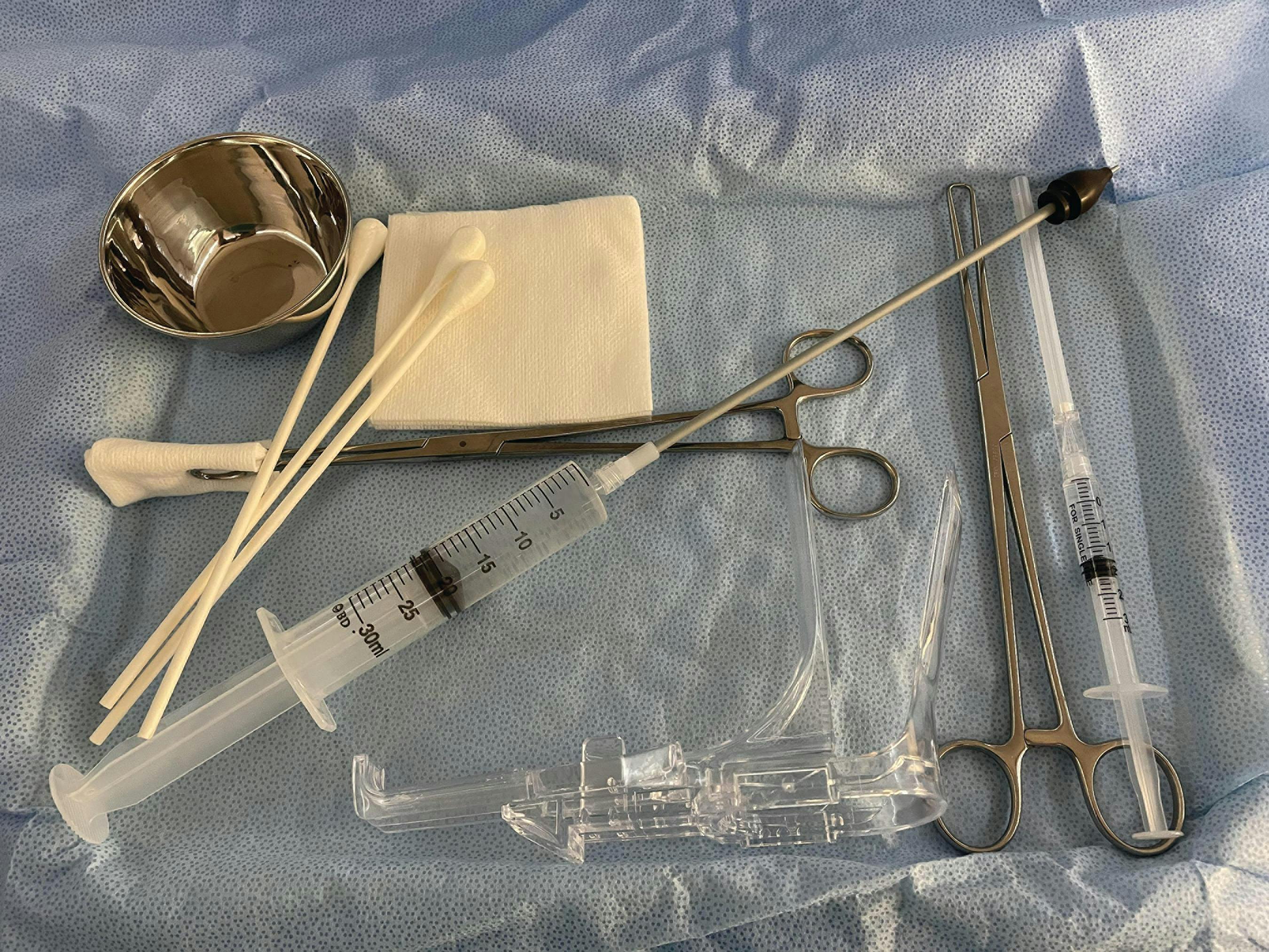 FIGURE 1. Suggested instrumentation to perform a hysterosalpingogram include a speculum, large swabs, sterile 4 x 4 gauze pads, a small solution basin, local anesthetic, single-tooth tenaculum, a syringe attached to a cannula, and a ring forceps.